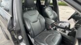 Front row of a black leather Jeep SUV interior, driver door open and seats visible in daylight