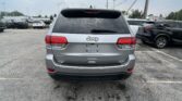 Rear view of a silver Jeep SUV in a parking lot, showing the Jeep logo and 4x4 badge on the tailgate.