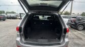 Open rear hatch of a gray SUV with an empty cargo area in a parking lot