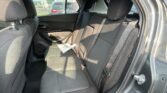 Rear passenger seat of a car with black fabric upholstery, headrests, and a paper resting on the seat cushion.