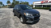 Dark gray Chevrolet SUV parked in a sunny lot with an EZ Auto storefront in the background.
