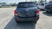 Rear view of a dark gray Chevrolet Trax AWD parked in a dealership lot among other SUVs.