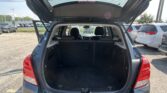 Open SUV trunk in a car lot, showing roomy cargo area and back seats visible behind it.