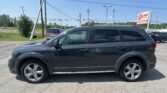 Dark gray SUV parked in a lot with power lines and a dealership sign in the background reading 'EZ Loan Auto Sales' on a sunny day.