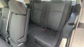 Rear passenger seating in a car with black fabric upholstery, three seats, and visible seat belts and headrests.