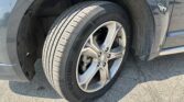 Close-up of a car wheel and tire, showing the tread and alloy rim with the wheel well in view.