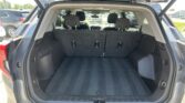 Open hatch in a SUV showing a spacious cargo area with third-row seats upright and no items inside.