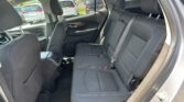 Rear passenger seating in a black cloth SUV interior with three seats and visible seat belts.