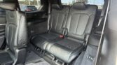 SUV interior showing black leather third-row seats with headrests and visible seat belts.