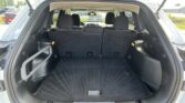 Open SUV trunk with rear seats upright and a spacious black carpeted cargo area.