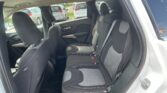 Rear passenger seating in a car: gray fabric bench with three seats, headrests, and visible seat belts