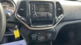 Center console infotainment screen displaying SiriusXM station 36 Alt Nation, with control buttons around and a parking lot visible through the windshield.