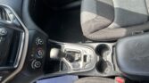 Interior of a car showing the center console with gear shifter, climate controls, cup holders, and part of the driver and passenger seats.