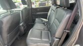 Black leather rear passenger seating in an SUV, with headrests, seat belts, and rear climate vent visible.