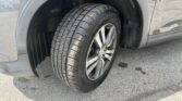 Close-up of a car's front right wheel with visible tire tread and fender.