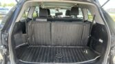 Hatch open to reveal a spacious SUV cargo area with folded third-row seats and a ribbed rubber floor mat