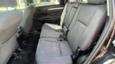 Rear passenger seating area of a gray fabric car interior with three seats and headrests visible.
