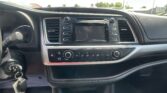 Center console inside a car: touchscreen infotainment system, air vents, and climate controls visible with the steering wheel on the left and keys in the ignition.