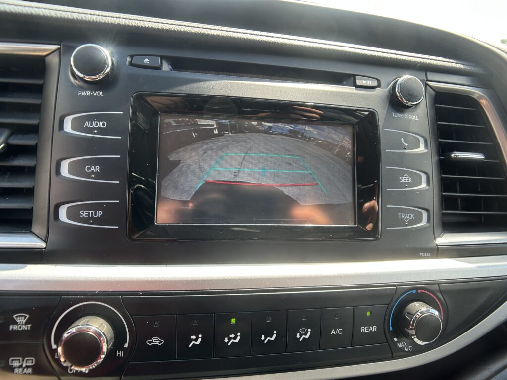 In-dash car display showing a rear-view camera feed with parking guide lines