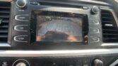 In-dash car display showing a rear-view camera feed with parking guide lines