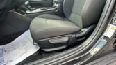 Inside a car cabin showing the front passenger seat, center console with gear shifter and armrest, and door panel on the left.