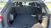 Open rear hatch of a dark SUV with cargo area and folded rear seats visible in the foreground