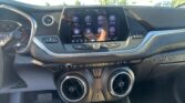 Dashboard touchscreen displaying apps like Audio, Phone, Wi‑Fi, and Settings inside a car.