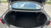 Open trunk of a gray sedan with a spacious empty cargo area visible behind the rear window