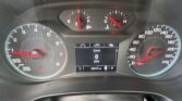 Car dashboard with three analog gauges (tachometer, fuel/temperature cluster) and a central digital speed display reading 0 mph; odometer shows 56,274 miles.