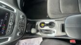 Interior of a car showing the center console with gear shift, cup holders, and climate controls next to the passenger seat.