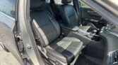 Front interior of a black car with leather seats, driver and passenger seating, center console visible.