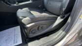 Interior of a car showing the front seat, center console, gear shifter, and seat belt buckle.