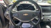Close-up view of a Chevrolet steering wheel with the dashboard and center console in a parked car.