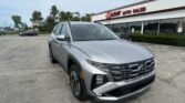Silver SUV in a dealership parking lot in front of EZ Auto Sales under a blue sky