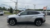 Silver SUV in a dealership lot with power lines overhead and an EZ Loans Auto Sales sign in the background.