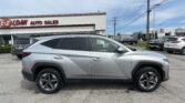 Silver SUV in foreground at an auto dealership lot with 'E-Z Loan Auto Sales' sign on the building left.