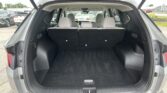 Open SUV cargo area with rear seats upright and empty space, view into the passenger area and parking lot behind the vehicle