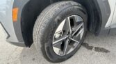 Close-up of a car's front wheel and tire, showing an alloy rim, the Kumho tire, and an orange side marker on the fender.