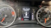 Close-up of a car instrument cluster: left tachometer, right speedometer, and a central digital display showing Vehicle Info, tire pressure, and odometer (120250 mi).