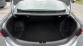 Open trunk of a gray car showing an empty dark cargo area lined with carpeting