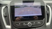 Rearview camera display on the car showing parking lot with orange guidance lines to assist backing up