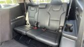 Black leather SUV rear row seats with two individual captain's chairs, headrests, and visible seat belts.