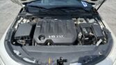 Open car hood showing engine bay with V6 VVT Direct Injection cover visible in the center of the image